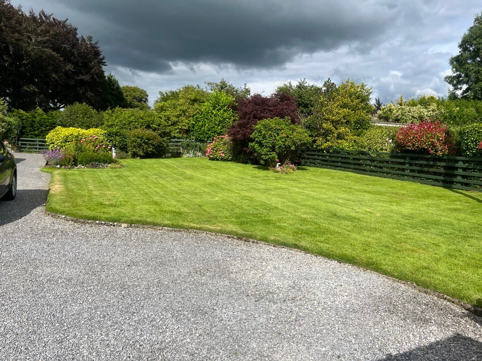 Curved back lawn with flower beds after a maintenance visit
